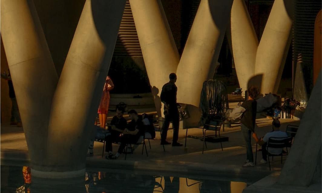 People gathered under a sunlit canopy